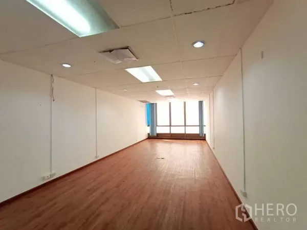 สำนักงาน ให้เช่า - พื้นที่ทำงานแบบโอเพ่นยาว พร้อมฝ้าเพดานและหน้าต่างบานใหญ่.