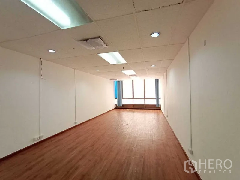 สำนักงาน ให้เช่า - พื้นที่ทำงานแบบโอเพ่นยาว พร้อมฝ้าเพดานและหน้าต่างบานใหญ่.