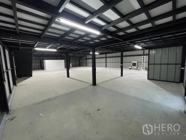 Warehouse for rent in Bueng Kum, Bangkok - Large open-plan mezzanine level under a metal roof with LED lighting and concrete flooring.
