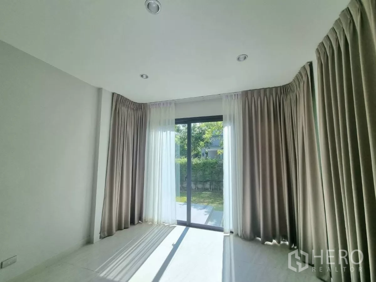 独立式住宅 出售在Prawet, Bangkok - 阳光房，推拉门连通露台与私家草坪。