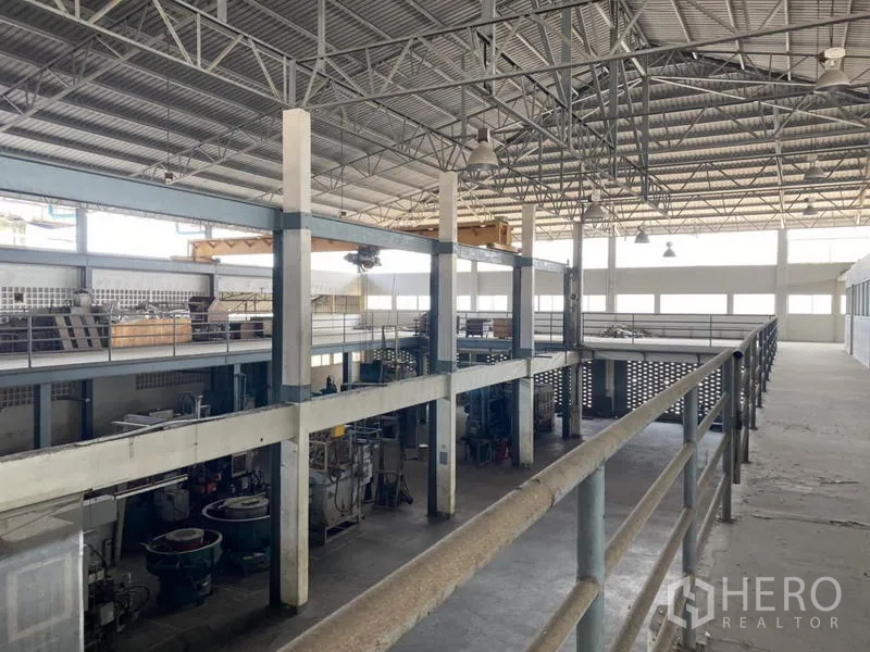 Factory for sale in Khlong Luang, Pathum Thani - Mezzanine walkway overlooking a production hall with a high steel truss roof.