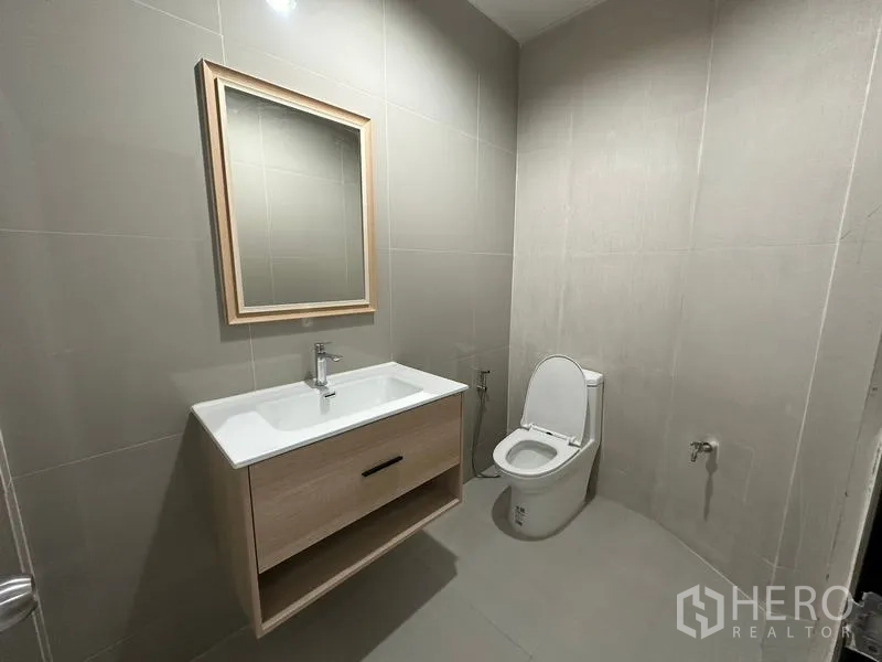 Townhouse for rent or sale in Phra Khanong, Bangkok - Laundry area with washing machine and door leading to kitchen.