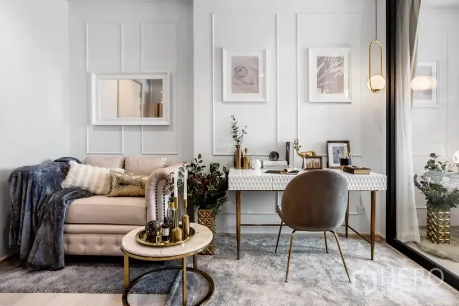 Condominium for sale in Pathum Wan, Bangkok - Cozy living nook with tufted sofa, marble coffee table and study desk by full-height window.