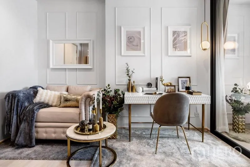 Condominium for sale in Pathum Wan, Bangkok - Cozy living nook with tufted sofa, marble coffee table and study desk by full-height window.