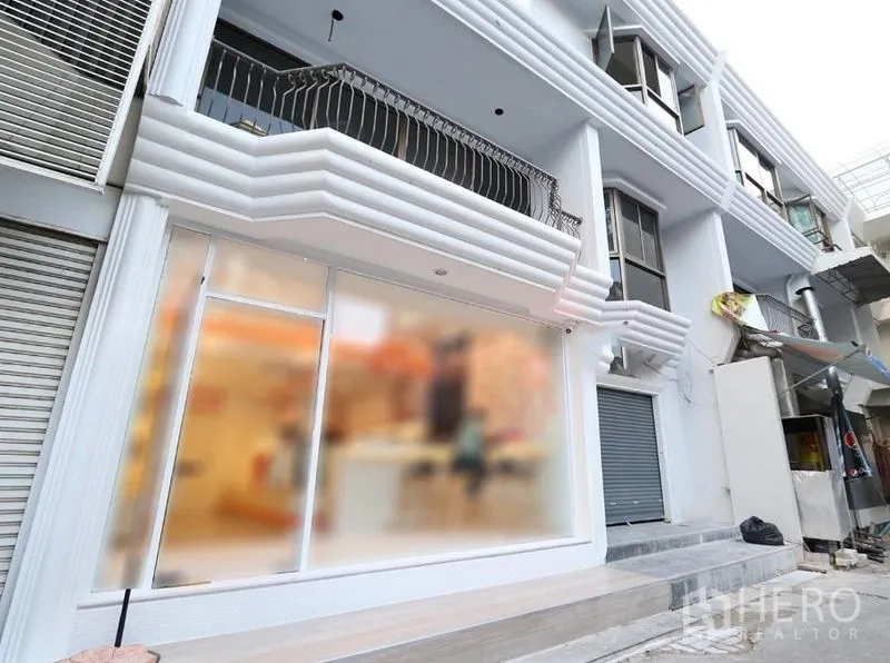 พื้นที่ขายปลีก ให้เช่าในPathum Wan, Bangkok - ด้านหน้าร้านสไตล์โมเดิร์นสีขาว กระจกเต็มบาน มีระเบียงและประตูม้วน ของอาคารพาณิชย์หลายชั้น