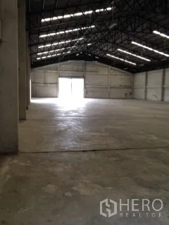 Warehouse for rent in Nakhon Pathom - Wide warehouse space showing high-clearance ceiling and bright access doors at both ends.