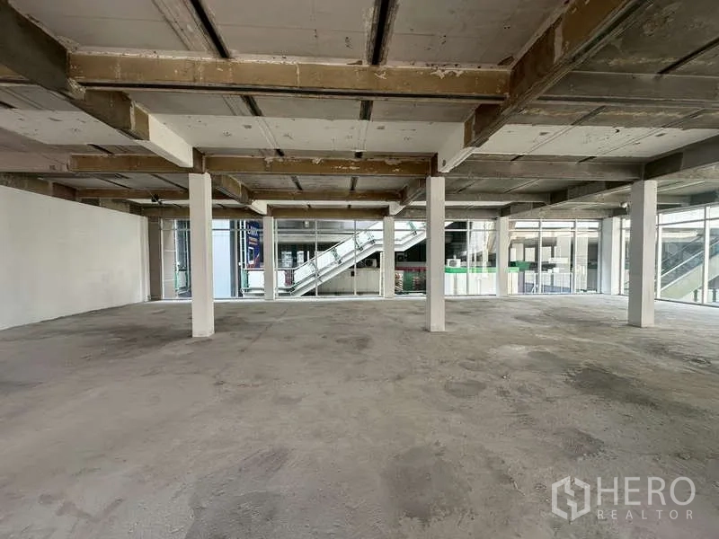 零售空间 出租在Khlong Toei, Bangkok - 整面玻璃的零售区域，可见外部步道与楼梯。