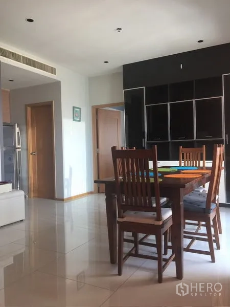 Condominium for rent - Dining area with wooden table and chairs next to a glossy storage cabinet.