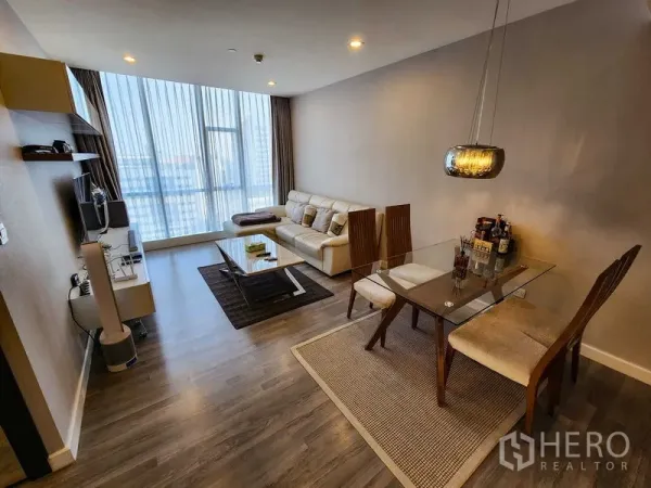 Condominium for rent or sale in Bang Rak, Bangkok - Living and dining space with a glass table, wood floors, and city view.