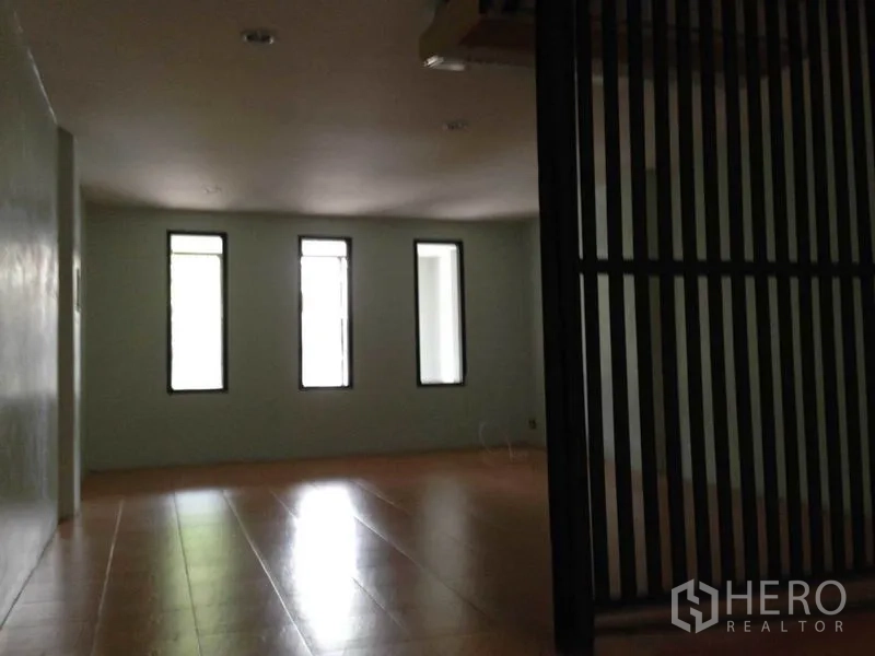 带办公室的家 出租或出售在Wang Thonglang, Bangkok - 室内开放空间，三扇窄窗与浅色地砖，旁有黑色栅格隔断，曼谷居家办公房。