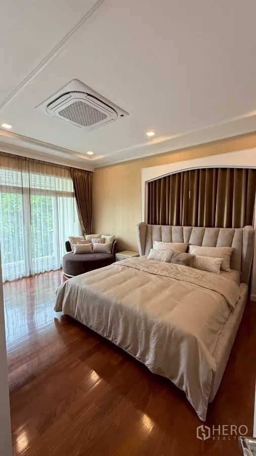Detached House for rent or sale in Bang Phli, Samut Prakan - Spacious master bedroom with king bed, seating alcove and wood flooring