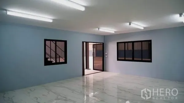 Warehouse for rent in Bueng Kum, Bangkok - Open-plan office with windows and a sliding glass door to the warehouse floor.