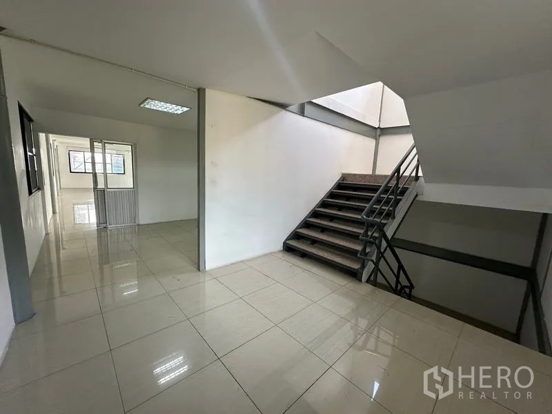 Warehouse for rent in Suan Luang, Bangkok - Stairwell and landing connecting office floors with natural light.