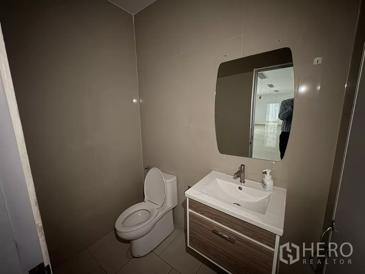 货栈 出租在Bang Phli, Samut Prakan - 现代化洗手间，坐便器、洗手台与墙面镜。