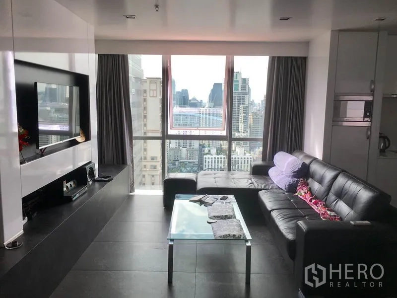 公寓 出租在Watthana, Bangkok - 现代客厅，黑色皮沙发与玻璃茶几，落地窗俯瞰曼谷天际线