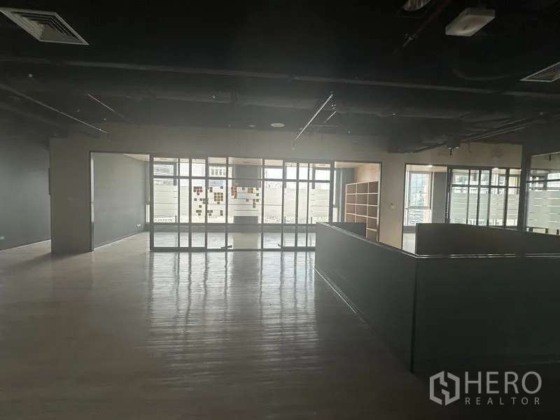 Office Space for rent in Bang Rak, Bangkok - Spacious office area with a central half-height counter and adjacent glass meeting rooms.