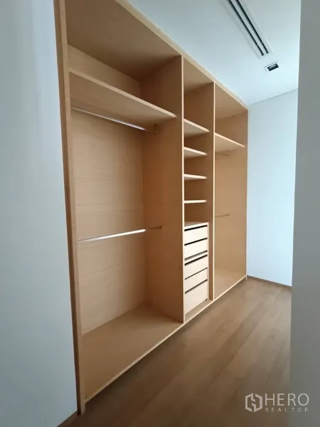 Condominium for rent or sale in Bang Rak, Bangkok - Built-in walk-in closet with light wood shelving, drawers and hanging space.