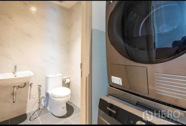 公寓 出租在Bang Na, Bangkok - 紧凑卫浴，马桶与洗手盆旁设有叠放式洗烘一体机。