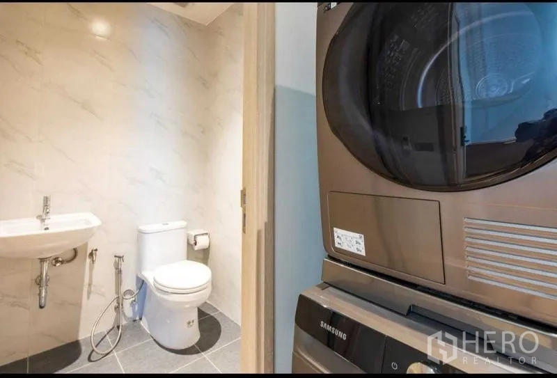 公寓 出租在Bang Na, Bangkok - 紧凑卫浴，马桶与洗手盆旁设有叠放式洗烘一体机。