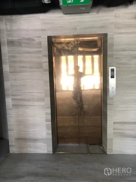 零售空间 出租在Khlong Toei, Bangkok - 瓦他那区零售大楼内的乘客电梯，金属门面现代感十足。