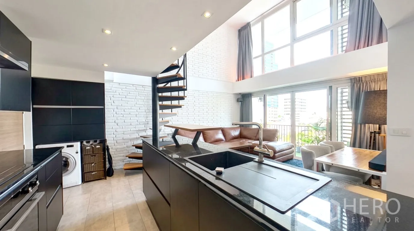 คอนโด for rent in Watthana, Bangkok - ไอส์แลนด์ครัวพร้อมอ่างล้างจานหันสู่ห้องนั่งเล่นสว่างและระเบียง