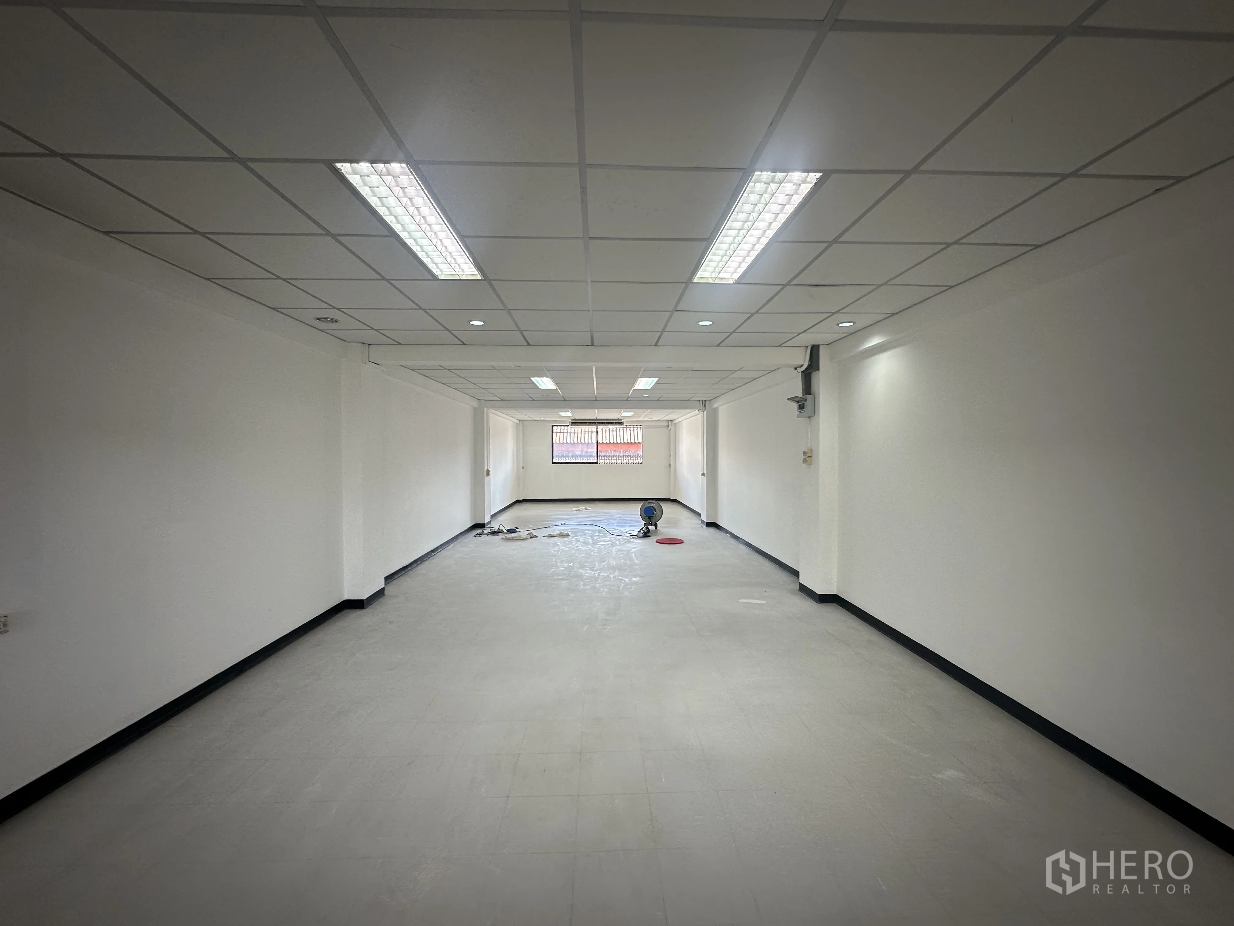 ออฟฟิศ for rent in Watthana, Bangkok - สำนักงานรูปทรงยาวสี่เหลี่ยม พื้นที่โล่ง ไฟดาวน์ไลท์และฟลูออเรสเซนต์ ผนังขาว หน้าต่างปลายห้อง