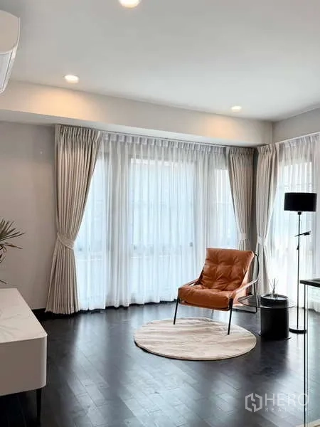 Detached House for rent or sale in Bang Phli, Samut Prakan - Sunlit sitting area with wraparound sheer curtains, recessed lighting and a leather accent chair.