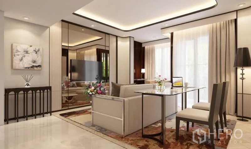 Condominium for rent in Watthana, Bangkok - Open‑plan lounge with cream sofa, wall mirror panels, TV, and a two‑seat dining table beside sheer curtains.