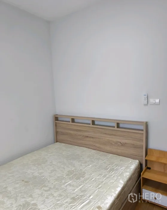 联排别墅 for rent in Bang Phli, Samut Prakan - 带木质床头与床头柜的卧室，墙面洁白。