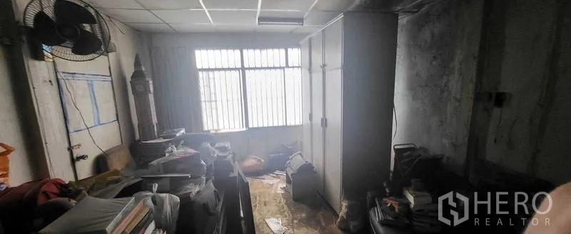 Shophouse for rent in Khlong Toei, Bangkok - Daylit room with barred windows and storage, showing renovation potential.
