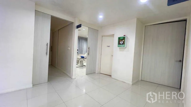 Standalone for rent in Khlong Toei, Bangkok - Clean lobby area with sliding doors opening to a clinic-style room and a restroom.