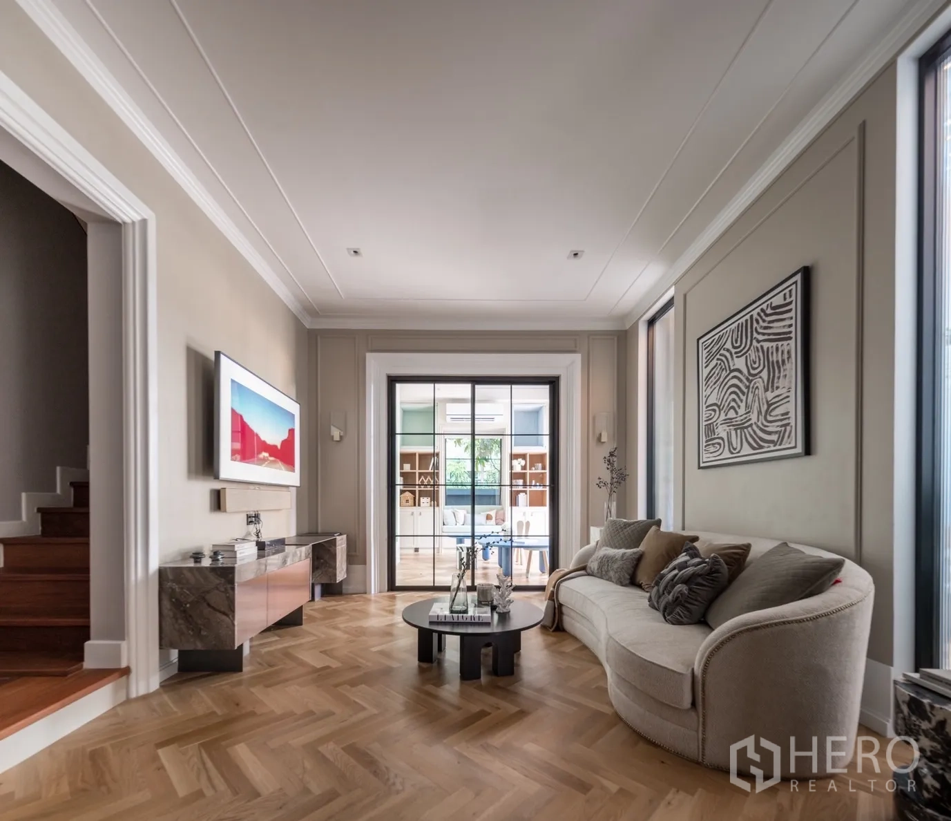 Detached House for rent or sale in Phra Khanong, Bangkok - Cozy family lounge with herringbone wood floor and glass doors to the study.