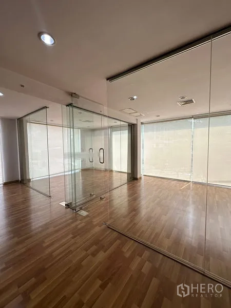 Office Space for rent in Pathum Wan, Bangkok - Corner meeting rooms with clear glass walls and wood floors.
