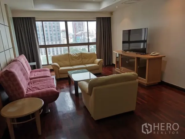 公寓 出租在Phaya Thai, Bangkok - 宽敞客厅，落地窗带城市景观，沙发与电视柜置于深色木地板上。