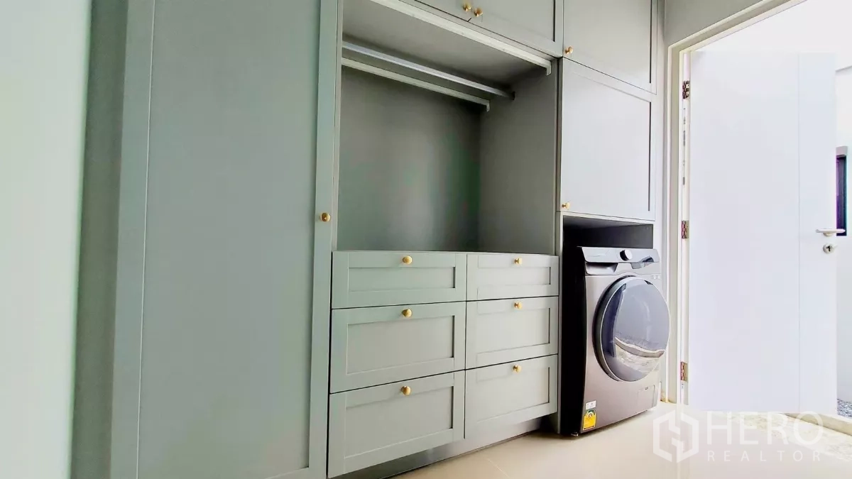 Detached House for rent in Lat Krabang, Bangkok - Laundry room with custom built-in wardrobes, drawers and a front-load washing machine.
