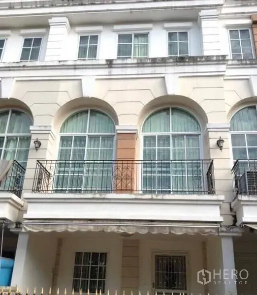 Townhouse for rent in Bang Kapi, Bangkok - Three-storey townhouse facade with arched windows and wrought-iron balconies.