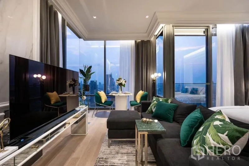 公寓 出租在Bang Rak, Bangkok - 奢华客厅，转角沙发与电视，落地窗俯瞰曼谷天际线