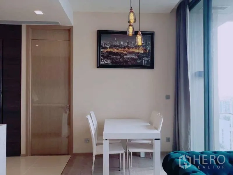 Condominium for rent or sale in Watthana, Bangkok - Bright dining nook with pendant lights beside sliding glass doors to the balcony.