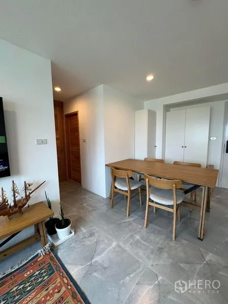 Condominium for rent or sale - Dining corner with wooden table and chairs beside white built-in storage cabinets.