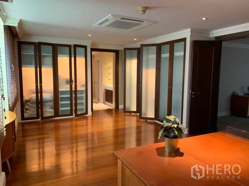 Condominium for rent or sale in Watthana, Bangkok - Flexible bedroom or study with polished wood floors, glass-front wardrobes and desk.