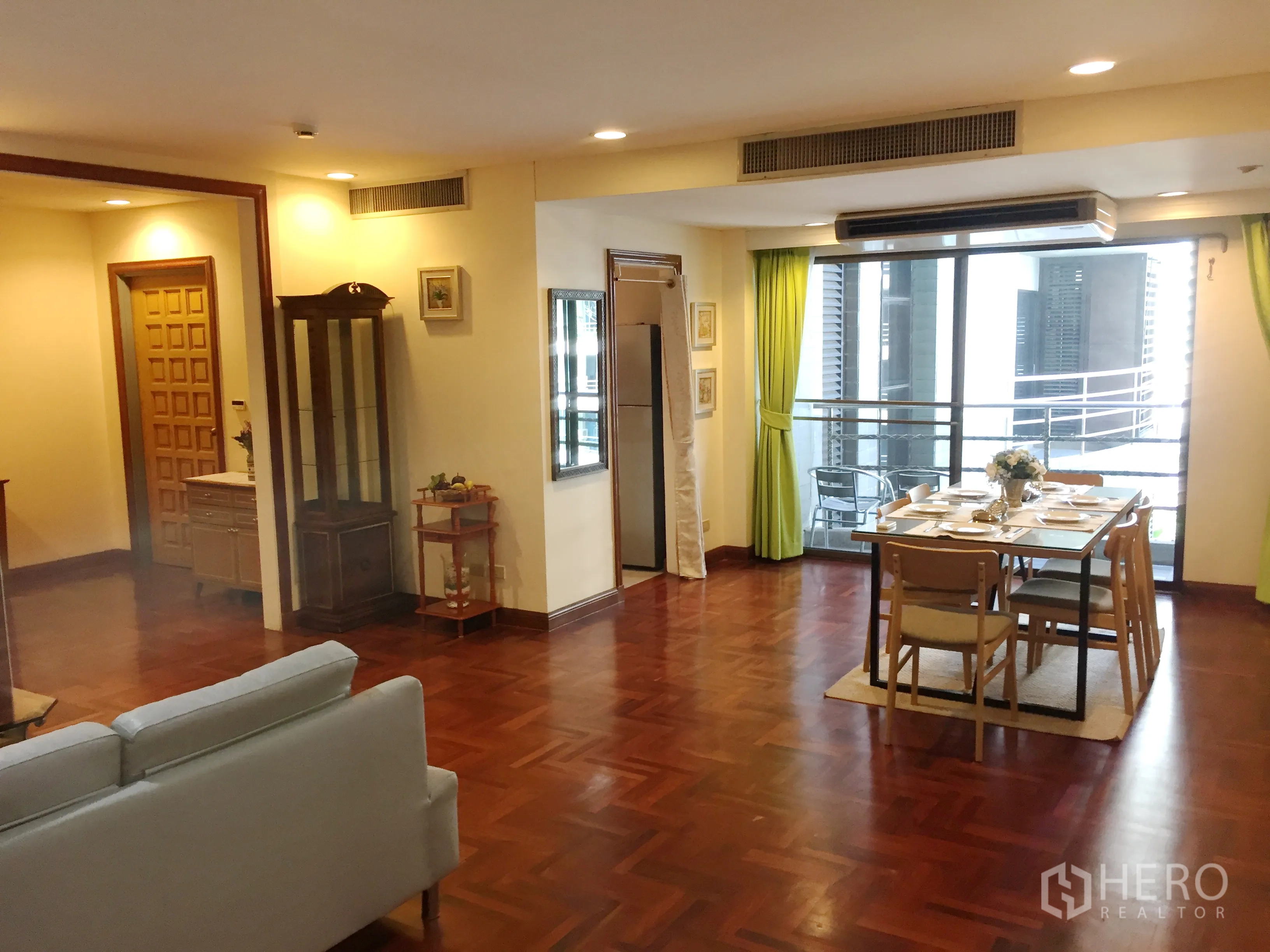 公寓 出租在Pathum Wan, Bangkok - 明亮客餐区，绿色窗帘，餐桌椅，连接阳台