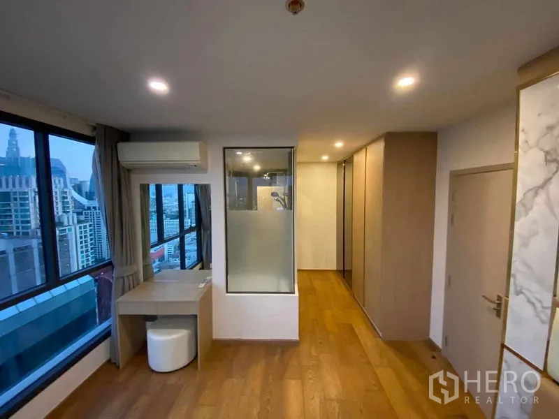 公寓 出租或出售在Ratchathewi, Bangkok - 主卧过道带梳妆台、衣柜与玻璃分隔的淋浴区。