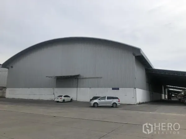 Warehouse for rent in Bang Pa-in, Phra Nakhon Si Ayutthaya - Front view of a large metal-clad warehouse with a curved roof and wide concrete yard.