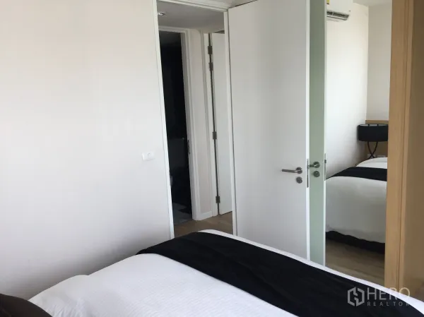 公寓 出售在Bang Rak, Bangkok - 次卧带镜面衣柜与白色房门，可通向浴室