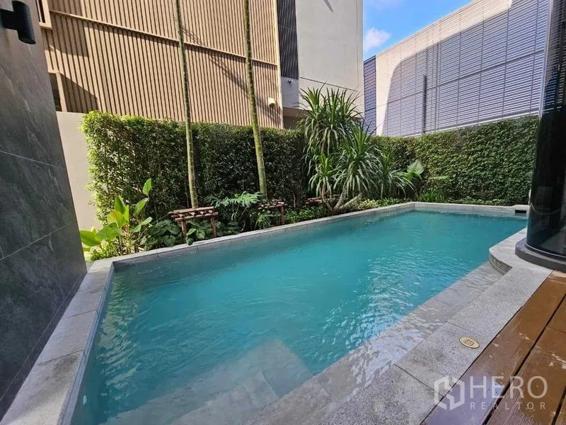 Detached House for rent in Wang Thonglang, Bangkok - Private swimming pool bordered by hedges and tropical plants.