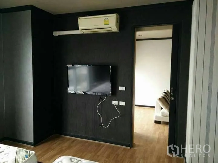 公寓 出租在Ratchathewi, Bangkok - 曼谷公寓客厅，墙挂电视、空调与木地板。