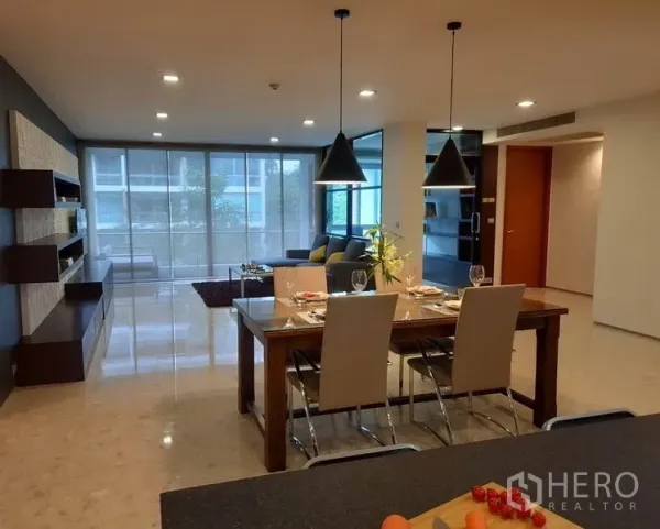 Condominium for rent in Khlong Toei, Bangkok - Spacious open living and dining zone with large glazing, warm lighting and polished floors.