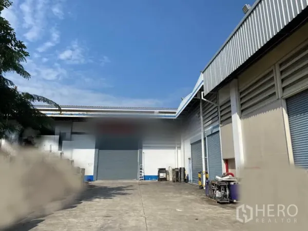 工厂 出租在Lam Luk Ka, Pathum Thani - 厂房外装卸区，数个卷帘门与宽阔混凝土场地并列。