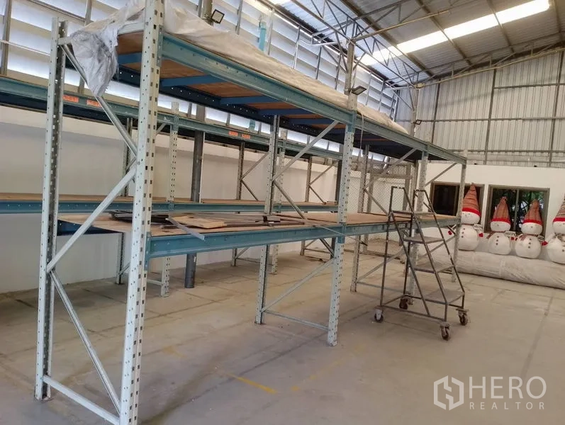 Warehouse for rent in Huai Khwang, Bangkok - Industrial shelving rows with rolling ladder in a bright, ventilated warehouse space.