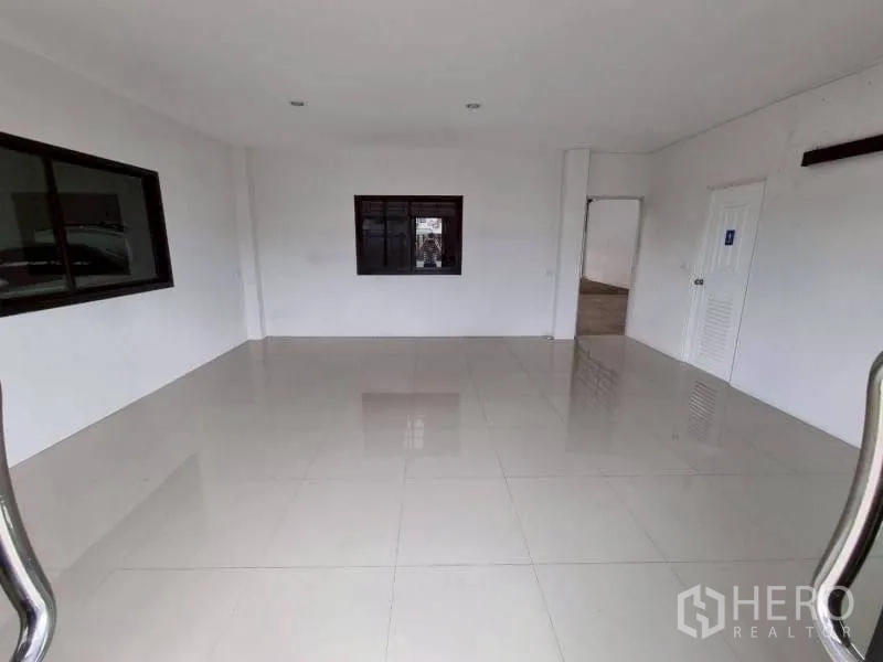 Warehouse for rent in Lam Luk Ka, Pathum Thani - Ground-floor office area with tiled flooring, windows, and internal doors.